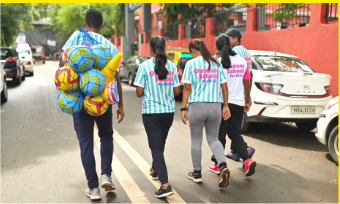 Girls carrying footballs